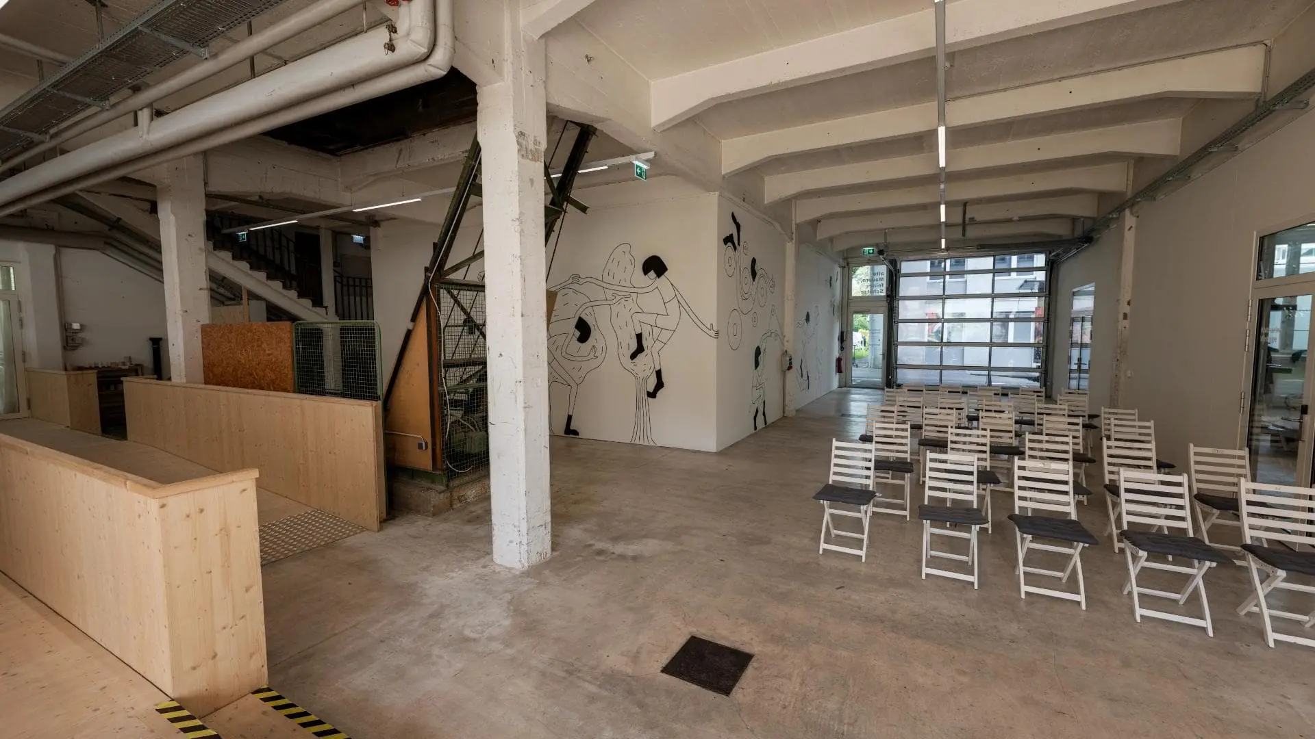 Leerer Raum mit Stühlen und Wandmalerei.