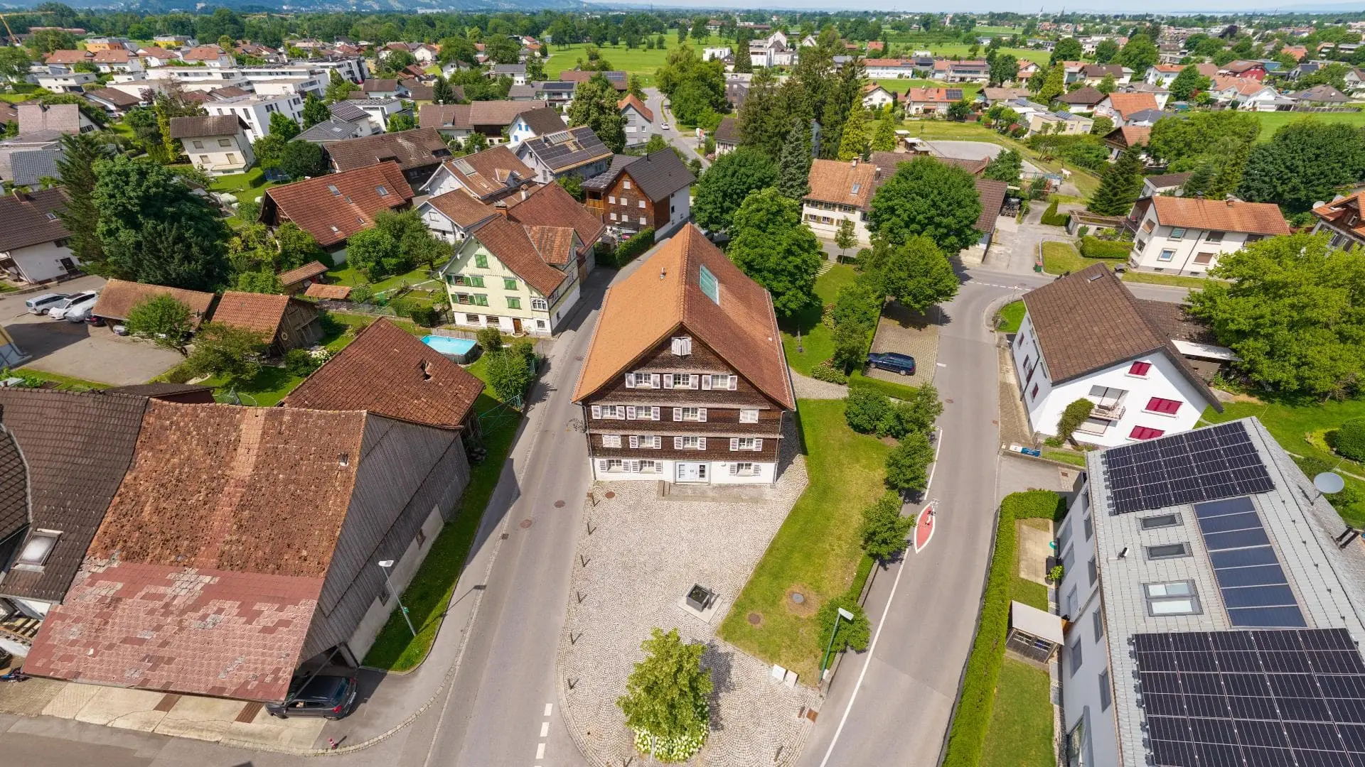 Luftaufnahme eines Dorfes mit Häusern und Bäumen.