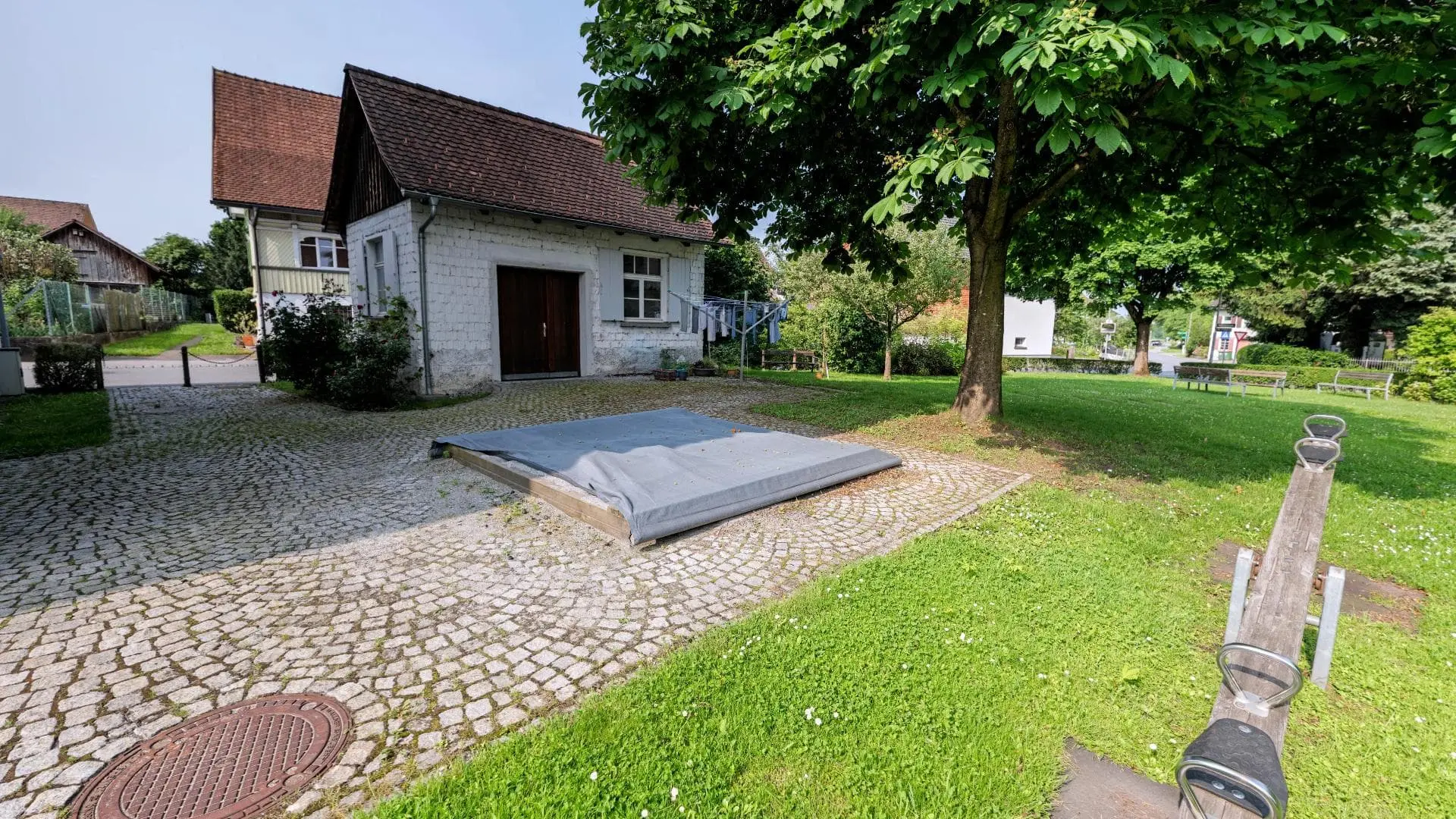 Idyllischer Garten mit kleinem Haus und Bäumen
