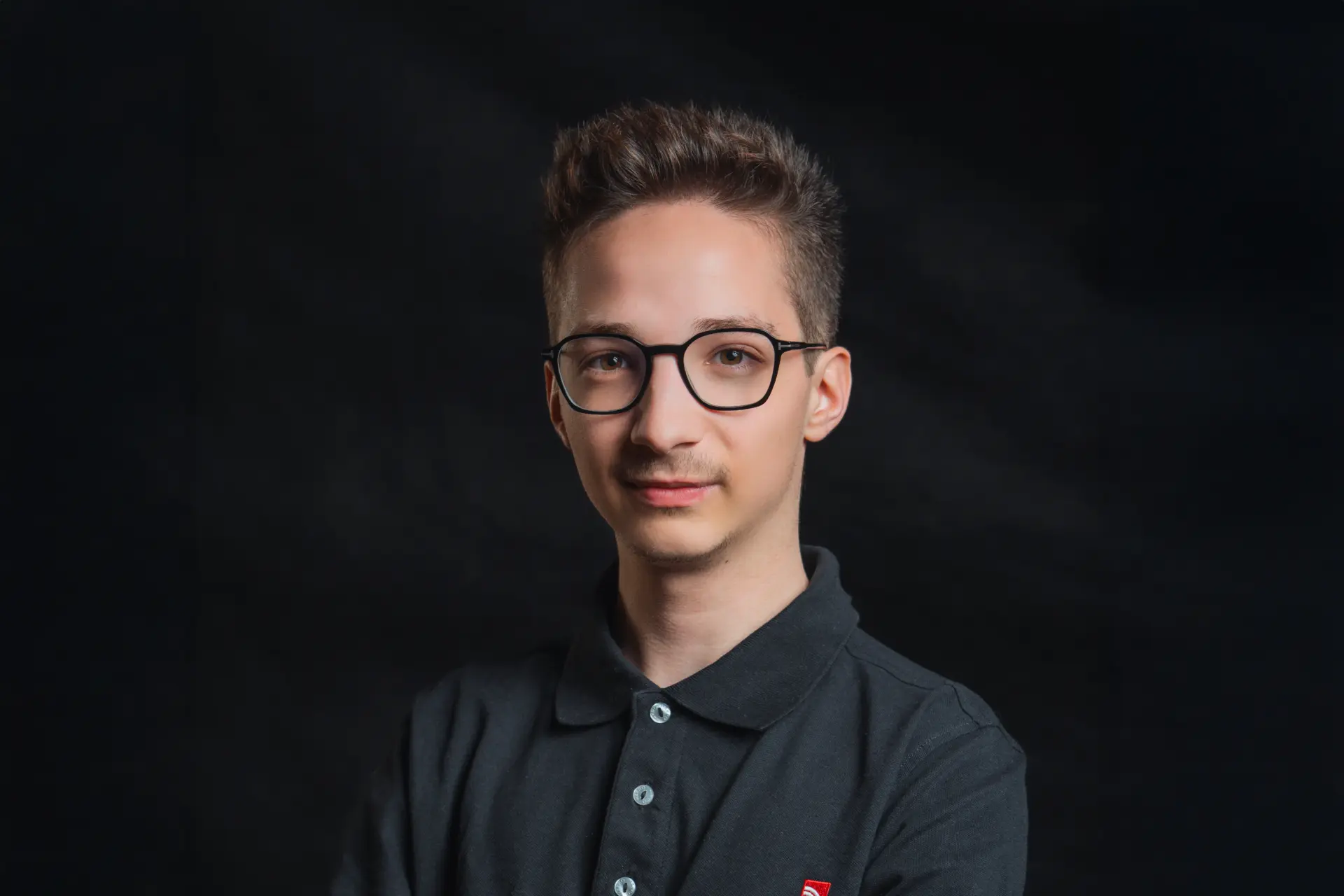 Mann mit Brille vor dunklem Hintergrund