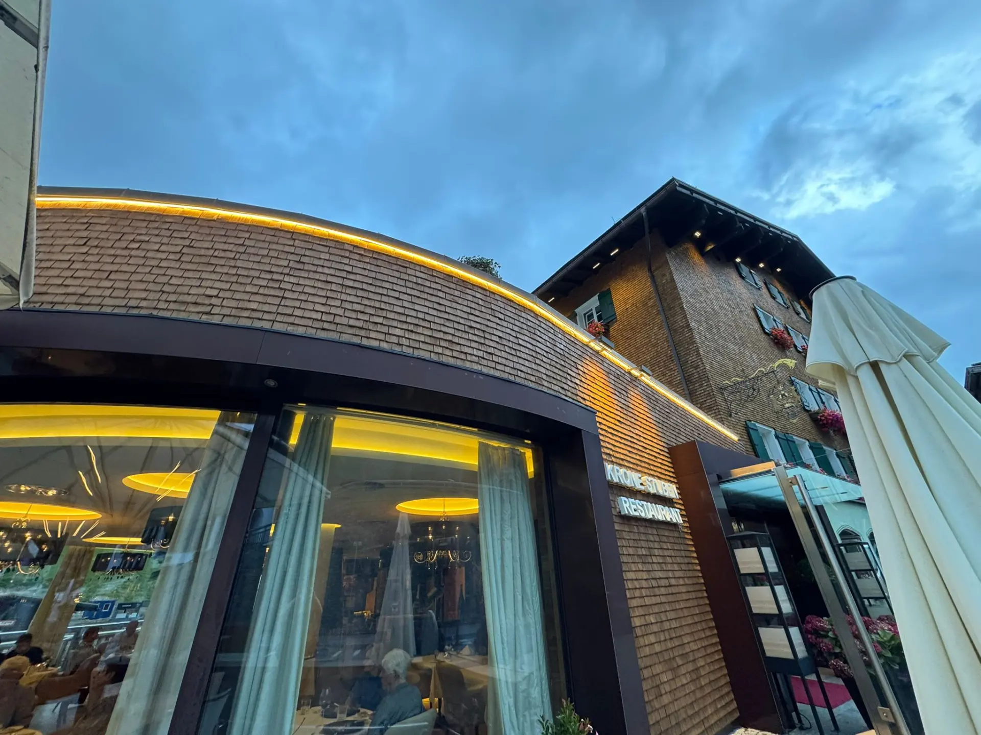 Restaurant mit Holzfassade und Beleuchtung.