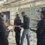 Besprechung auf einer Baustelle mit Leitern.