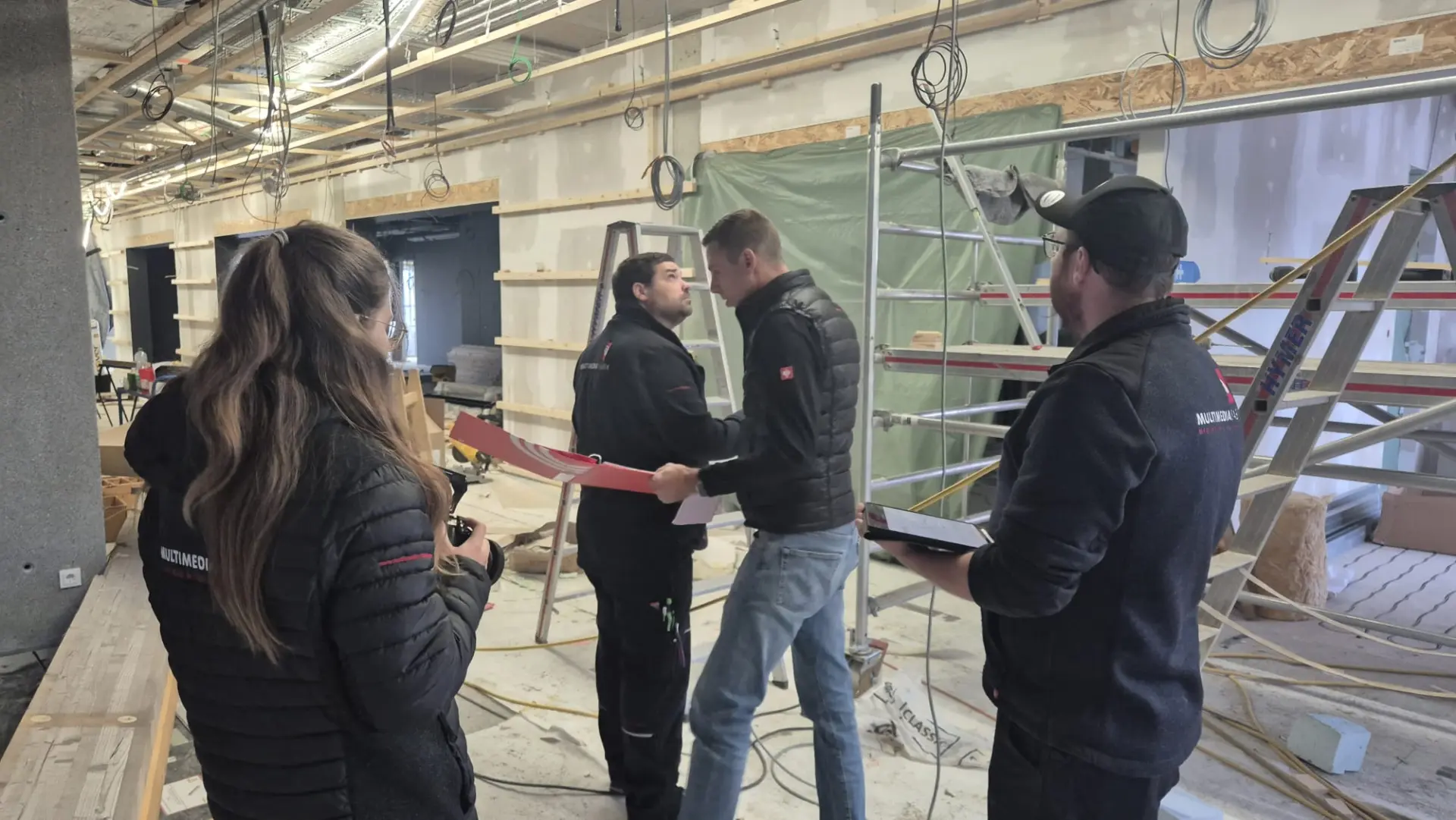 Besprechung auf einer Baustelle mit Leitern.