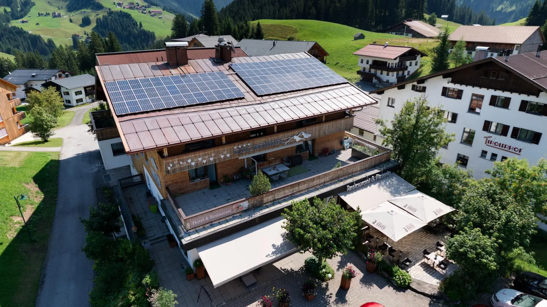 Hotelgebäude mit Solaranlagen in Alpenlandschaft