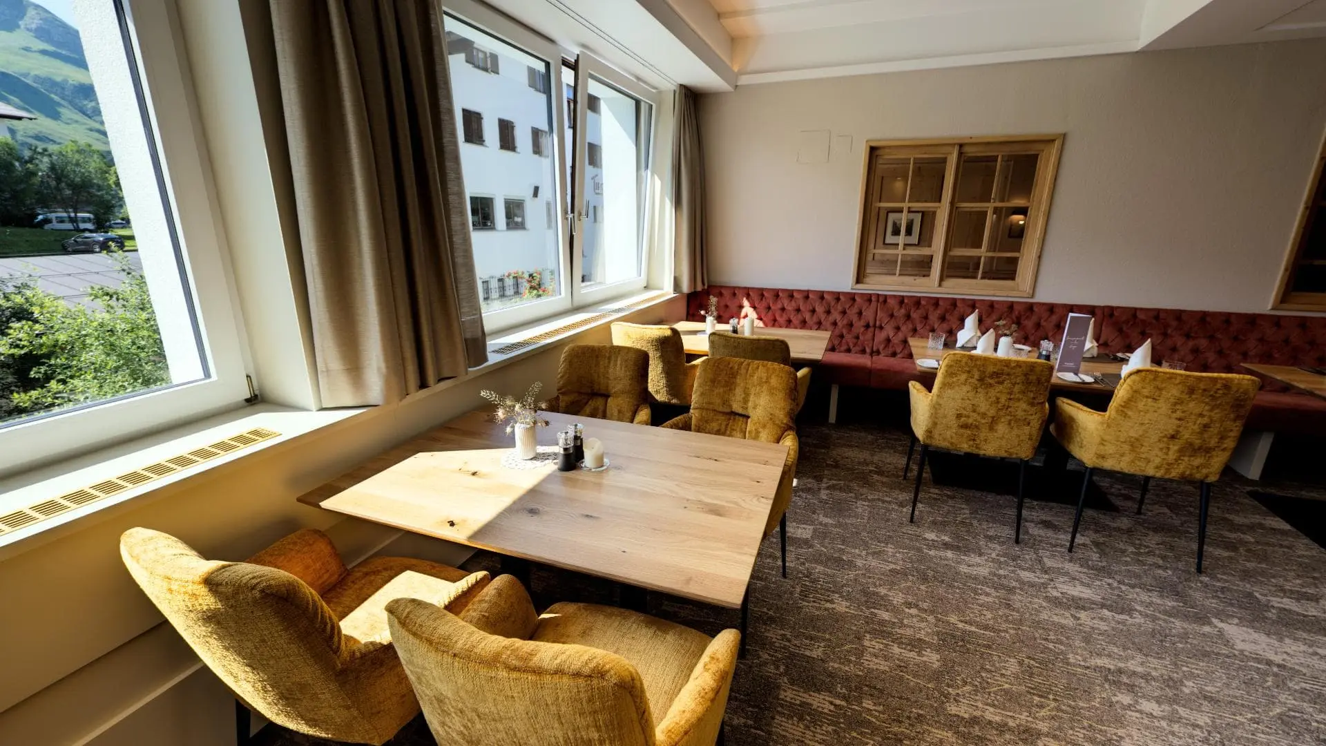 Gemütlicher Restaurantbereich mit großen Fenstern.