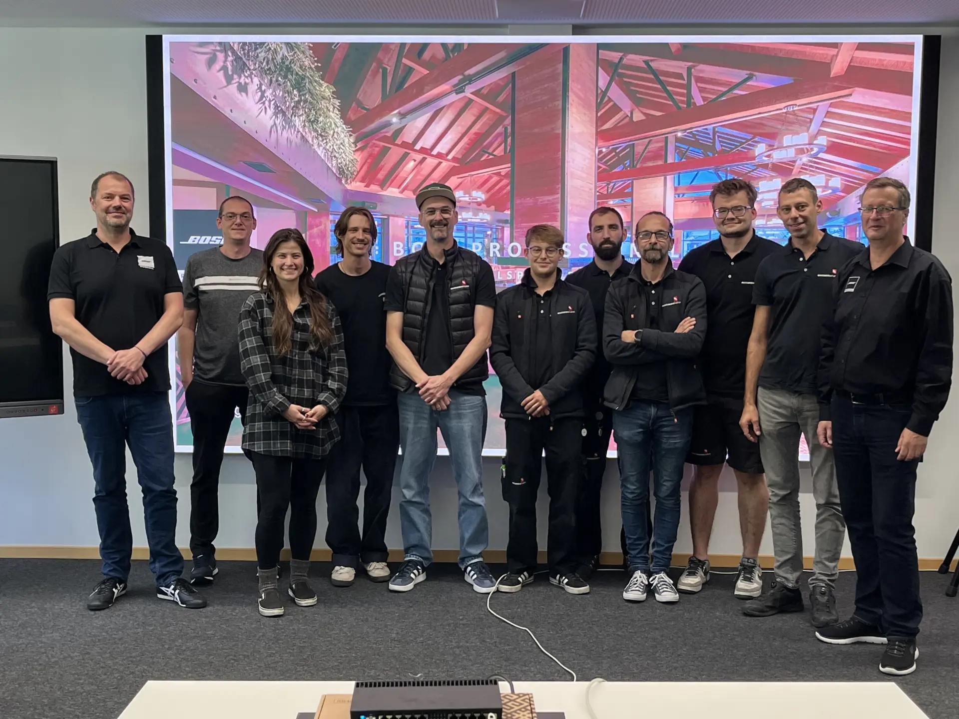 Gruppe von Menschen vor einer Leinwand versammelt.