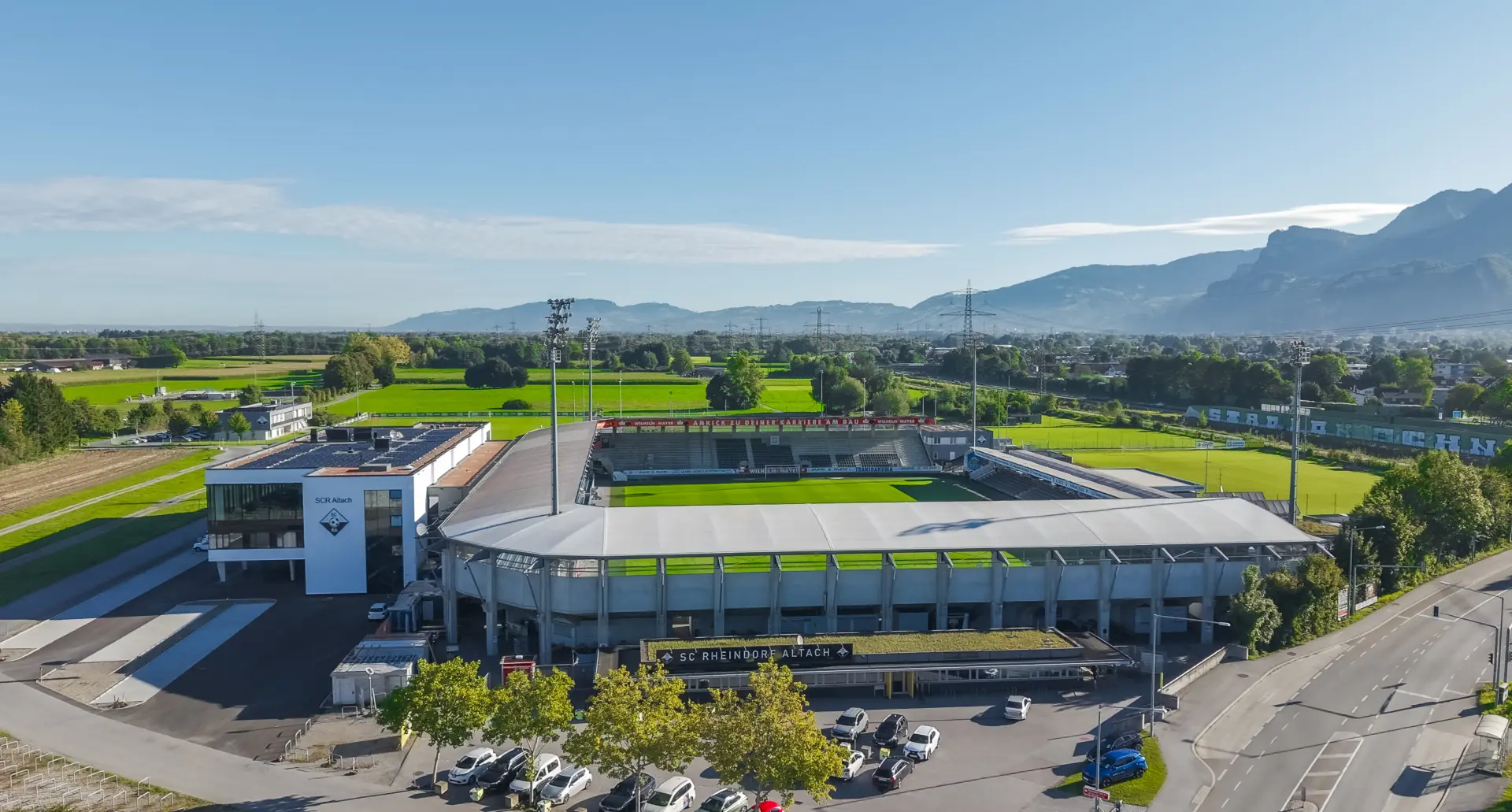 Fußballstadion mit umliegender Landschaft und Bergen