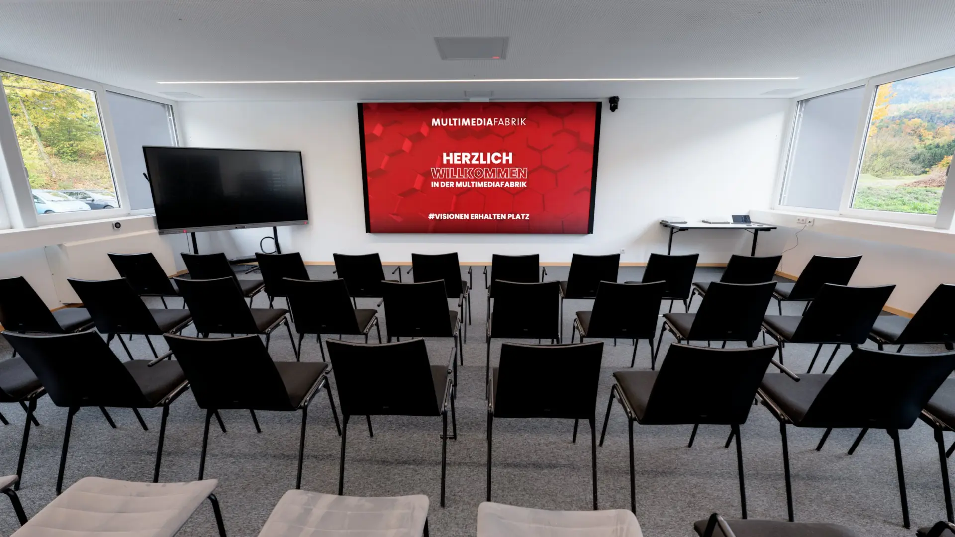 Leerer Seminarraum mit großen Bildschirm.