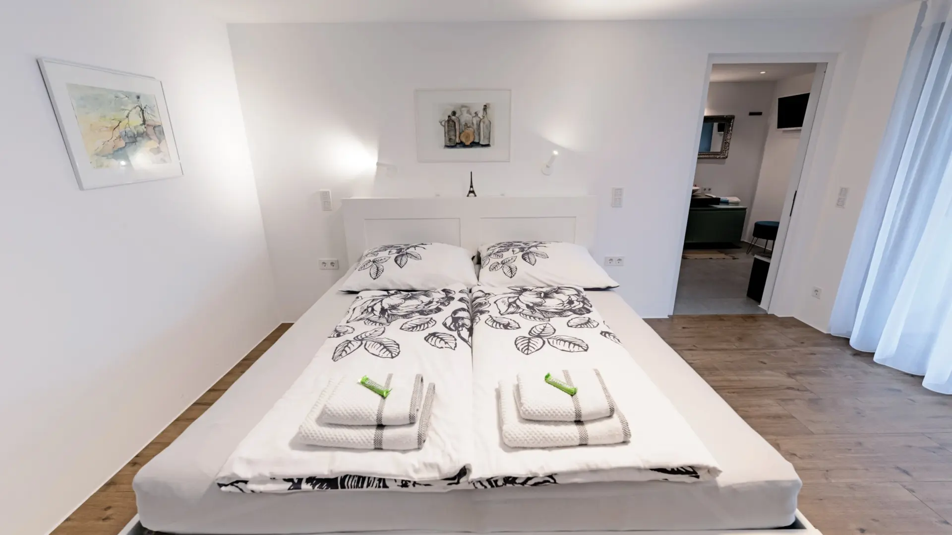 Modernes Schlafzimmer mit Doppelbett und Kunstwerken.