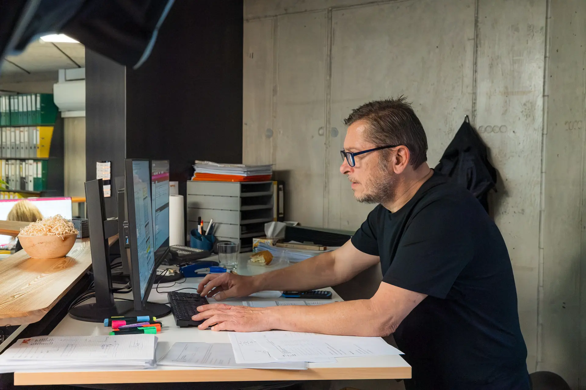 Mann arbeitet am Schreibtisch mit Computern.