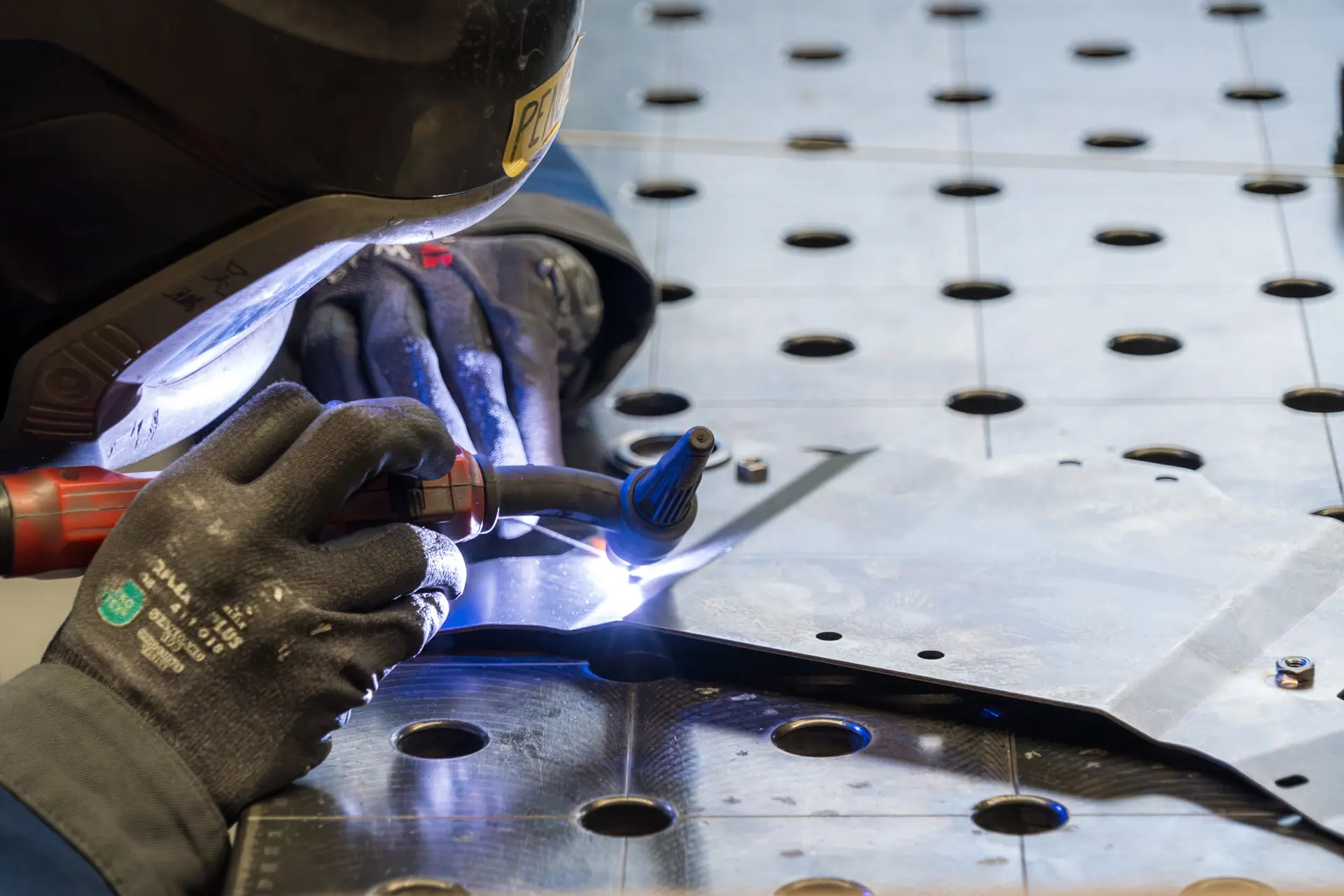 Hand beim Schweißen auf Lochblech