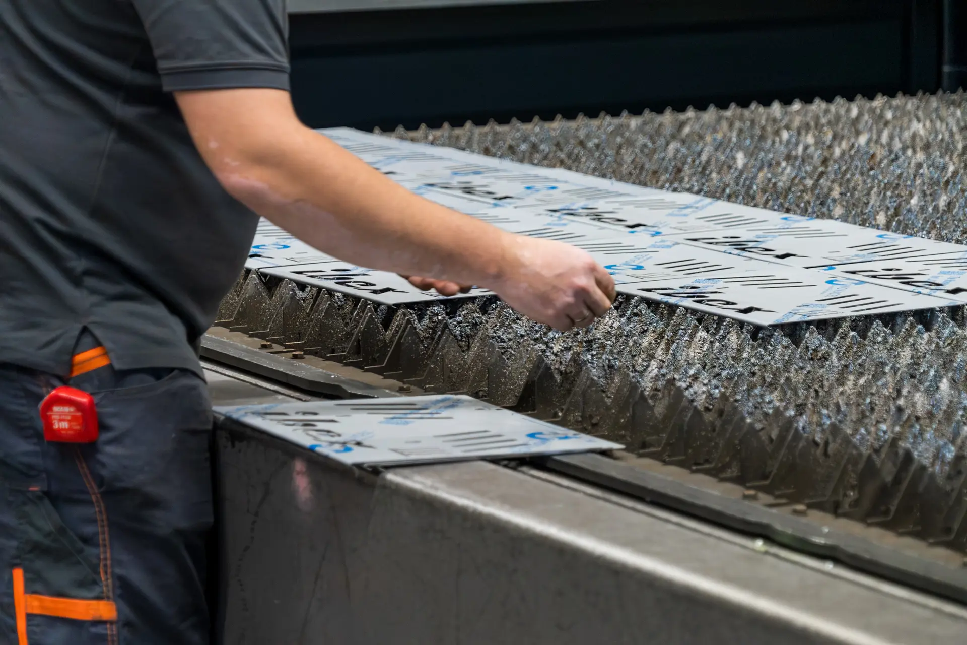 Arbeiter bearbeitet Metallschablonen auf Maschine