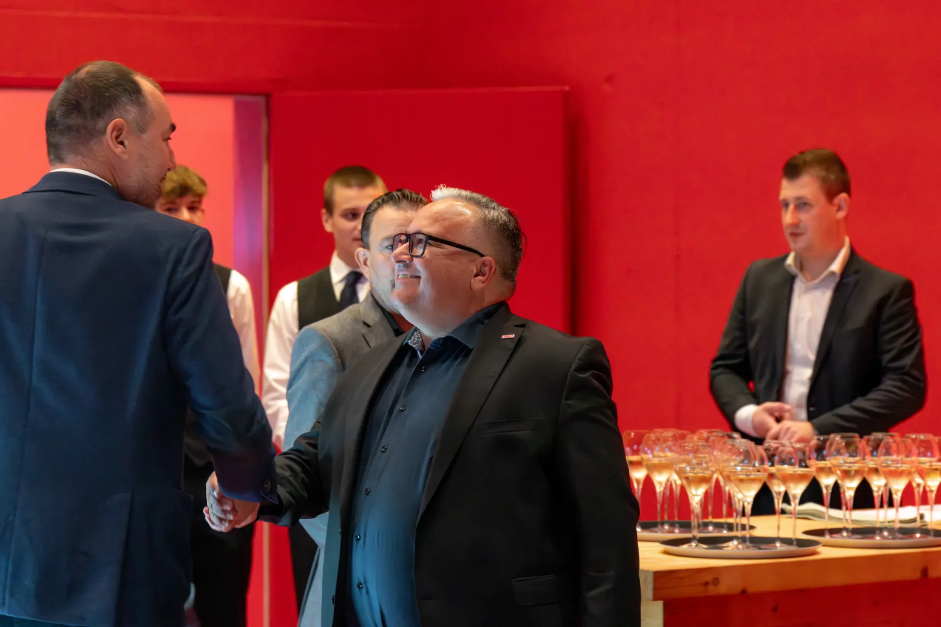 Männer im Anzug bei Empfang mit Getränken