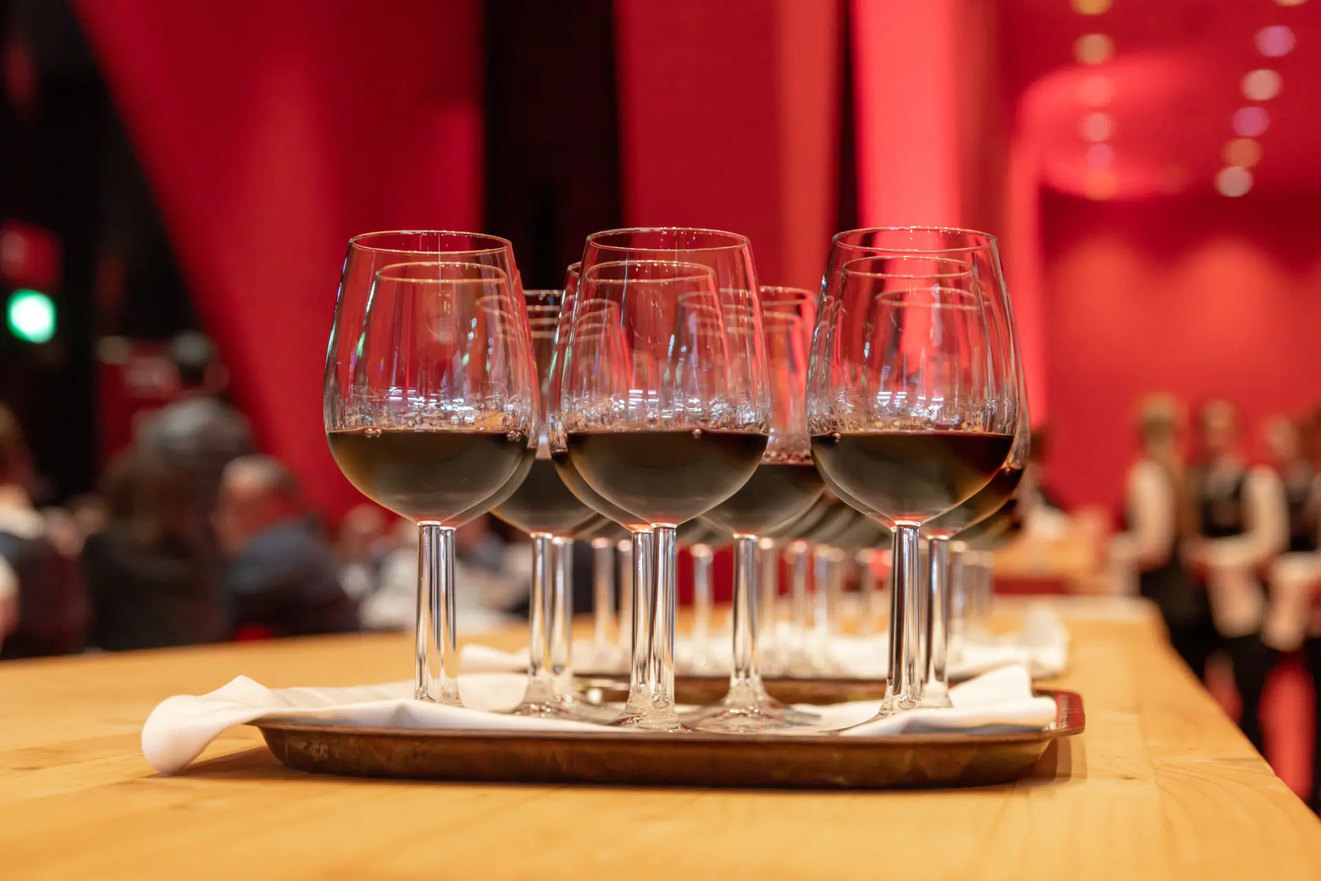 Tablett mit Rotweingläsern in rotem Ambiente