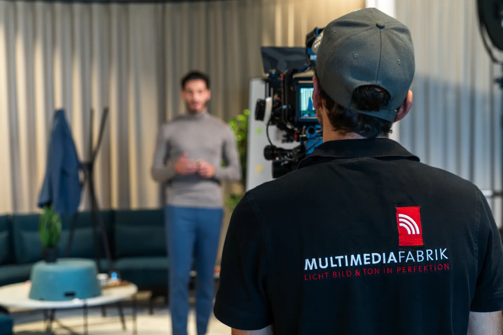 Kameramann filmt Mann vor Couch