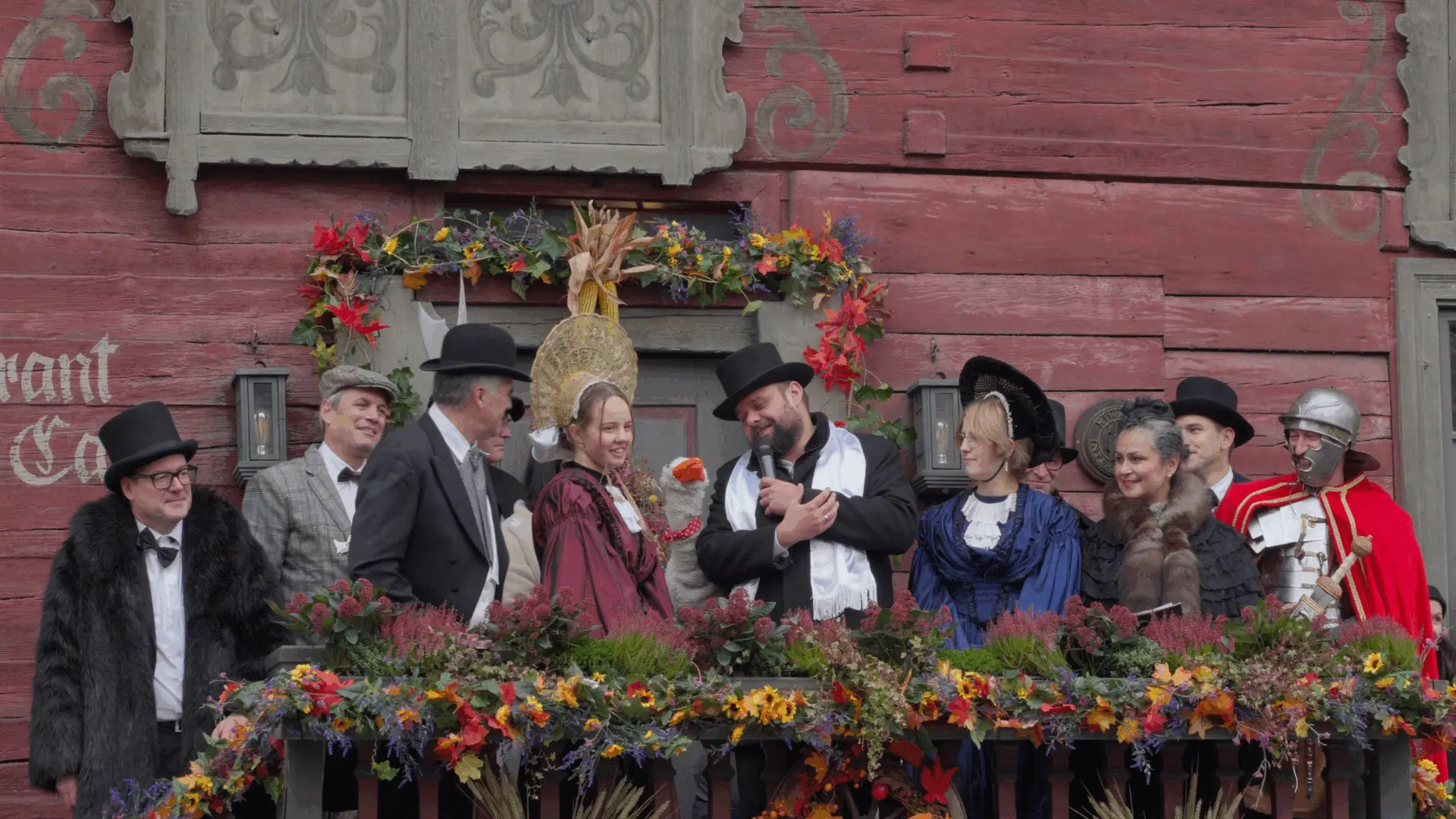 Personen in historischer Kleidung auf einer Blumenbühne.