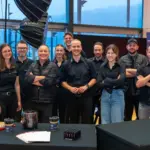 Gruppe von Menschen in schwarzer Kleidung lächelt