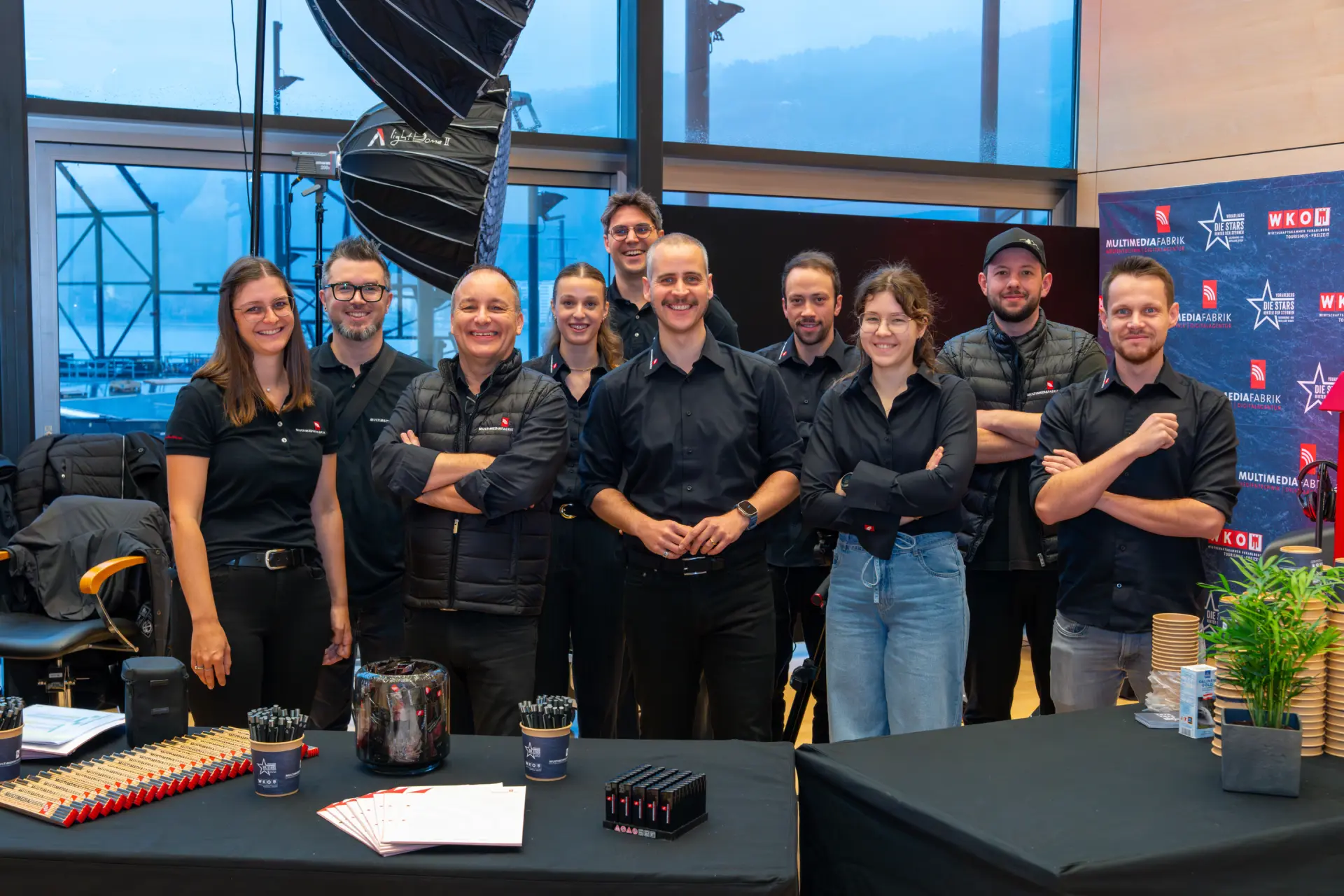 Gruppe von Menschen in schwarzer Kleidung lächelt