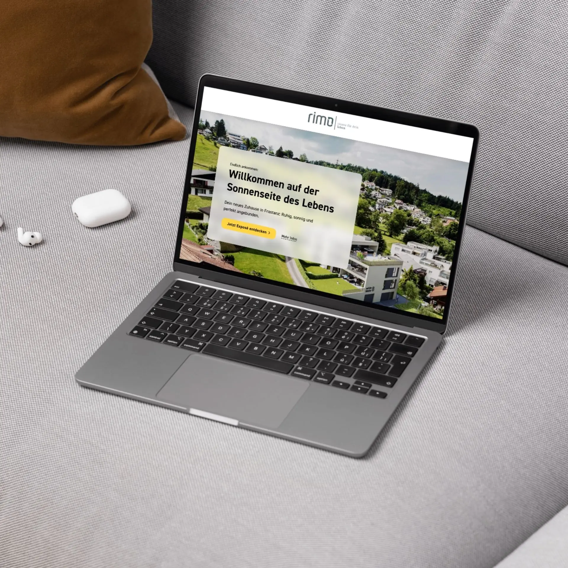 Laptop mit Immobilien-Website auf Couch