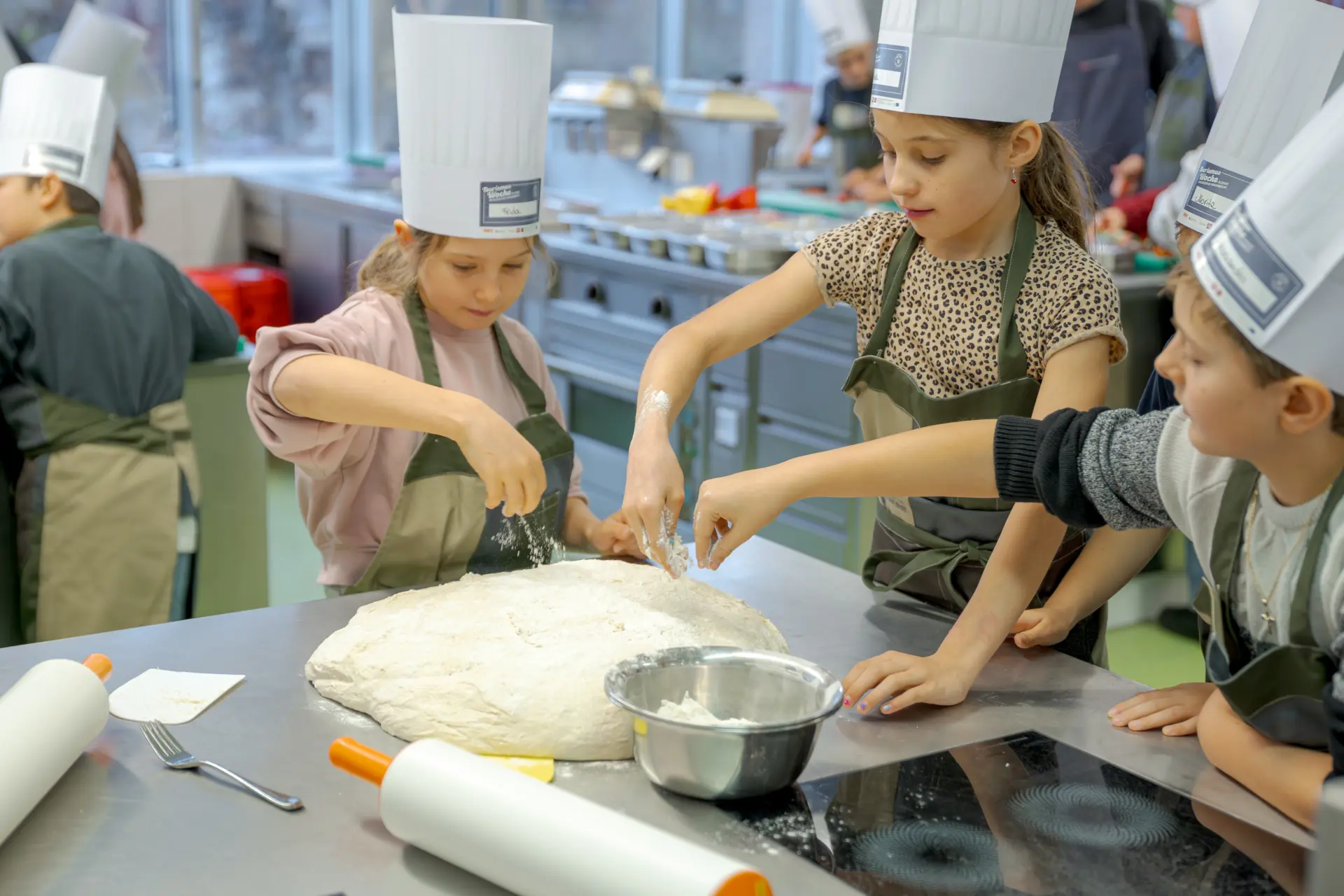 Kinder kneten Teig in Kochschule.
