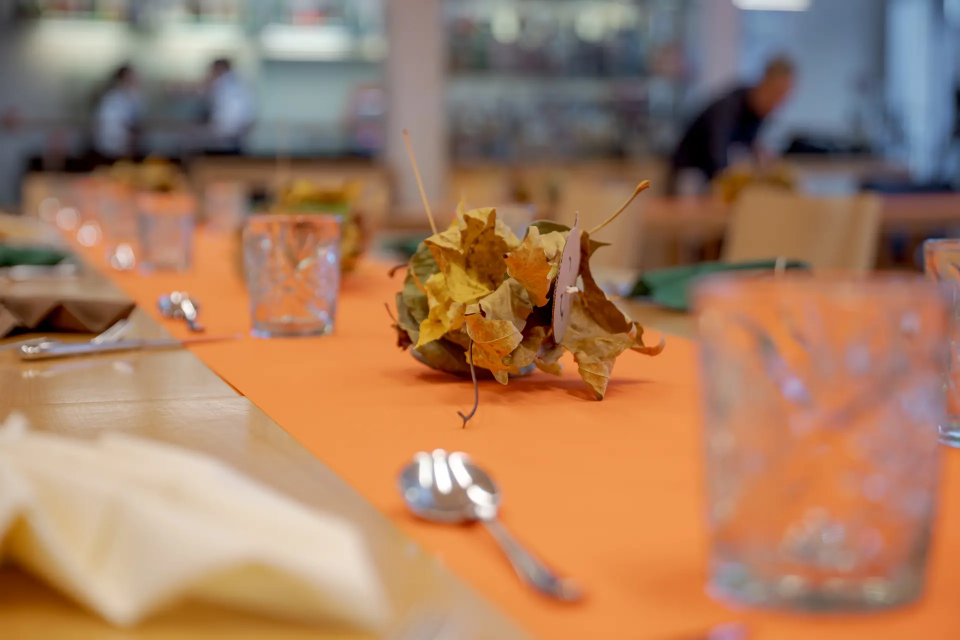 Herbstliche Tischdekoration mit Blättern und Gläsern