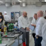 Köche diskutieren in professioneller Großküche.