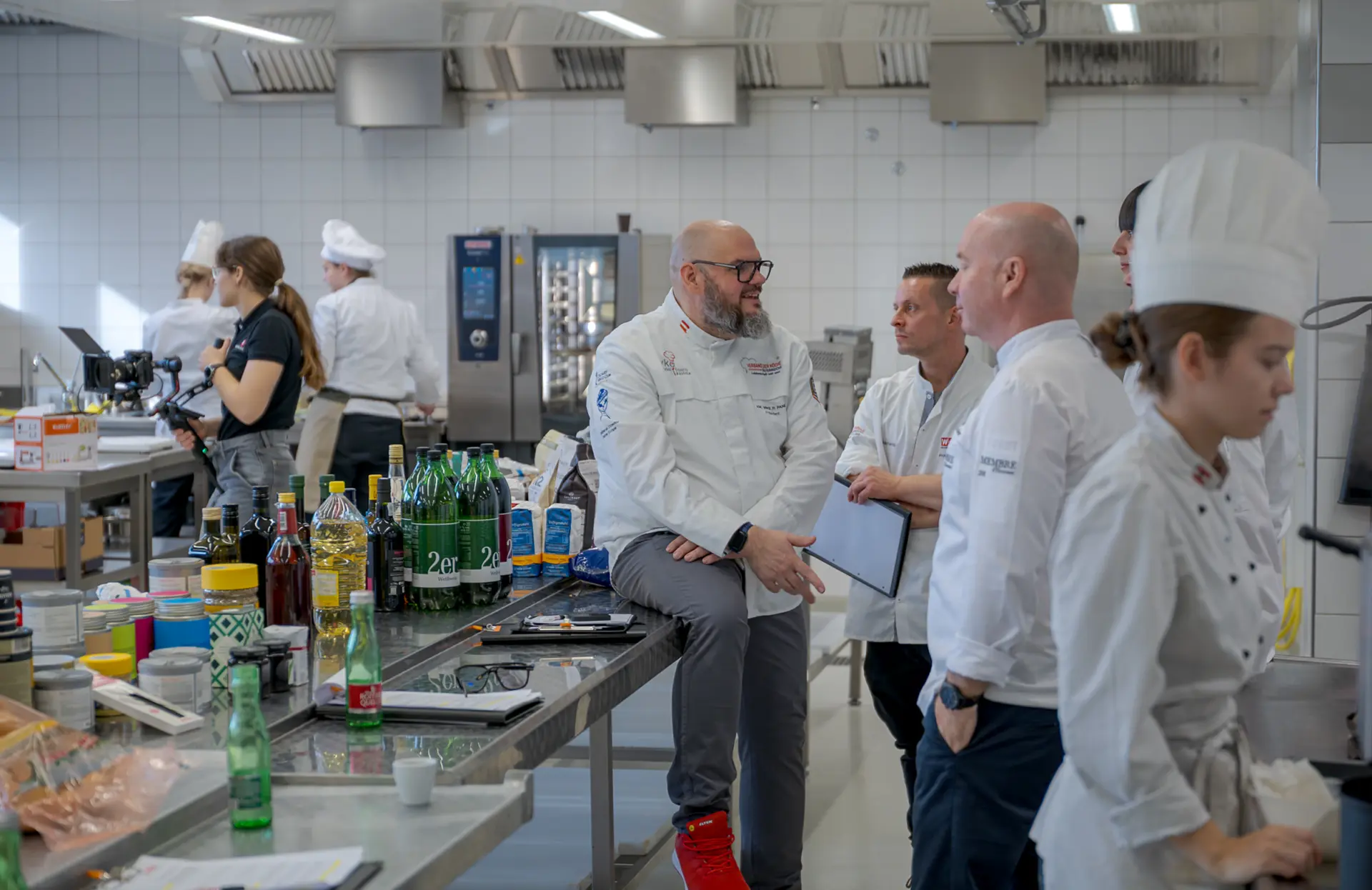 Köche diskutieren in professioneller Großküche.