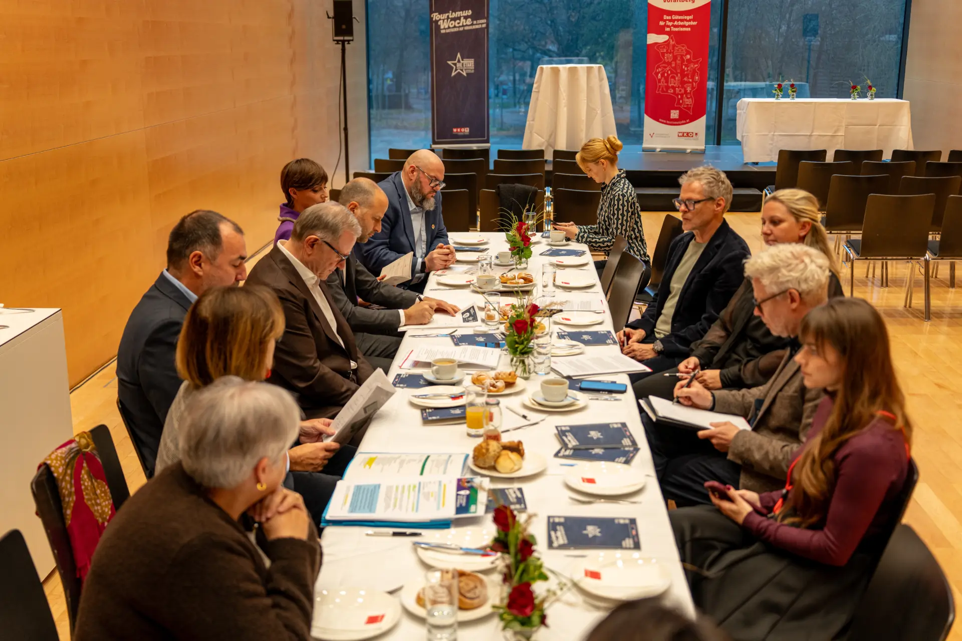 Gruppenmeeting am Konferenztisch mit Dokumenten.
