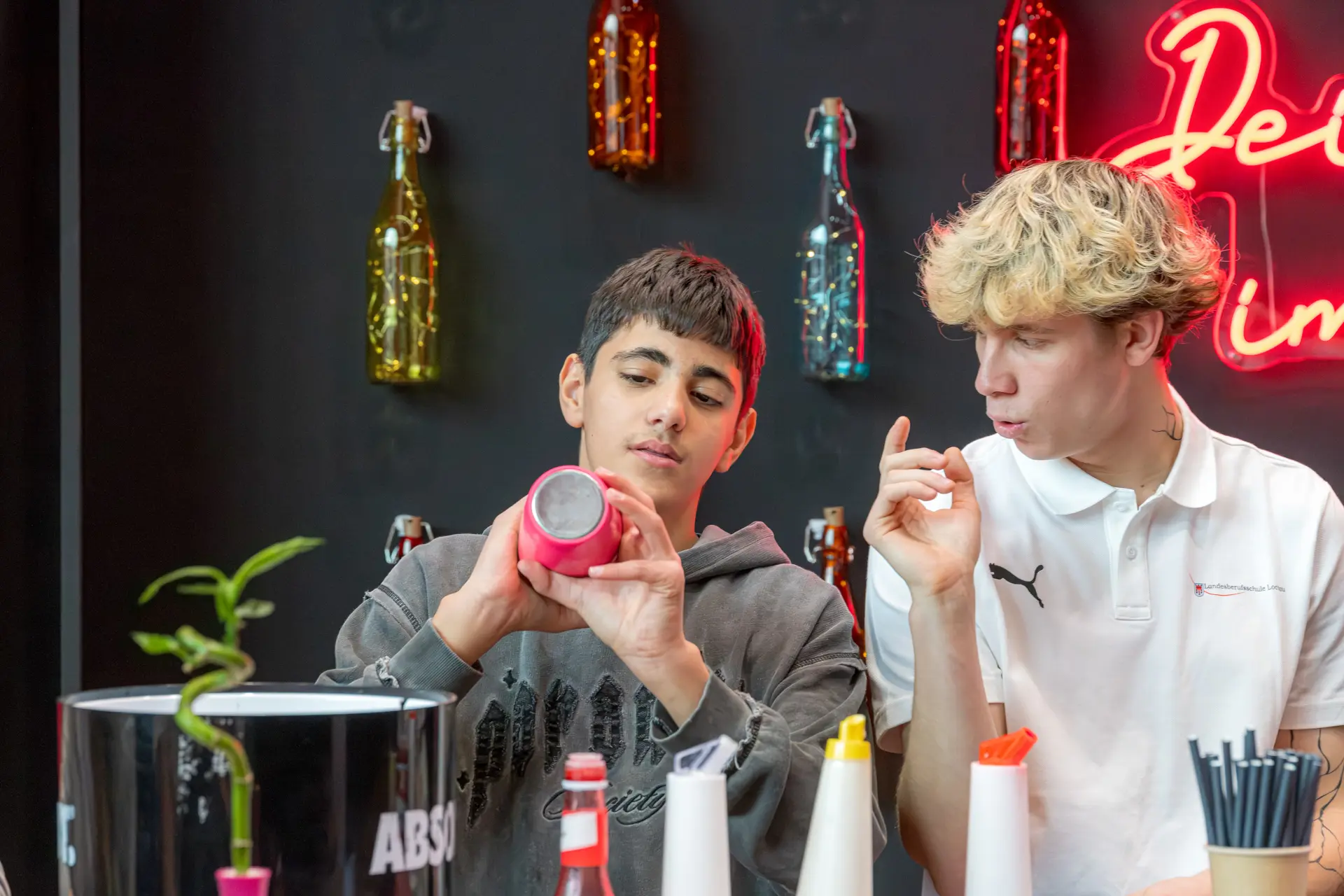 Zwei Jugendliche diskutieren über ein Objekt.