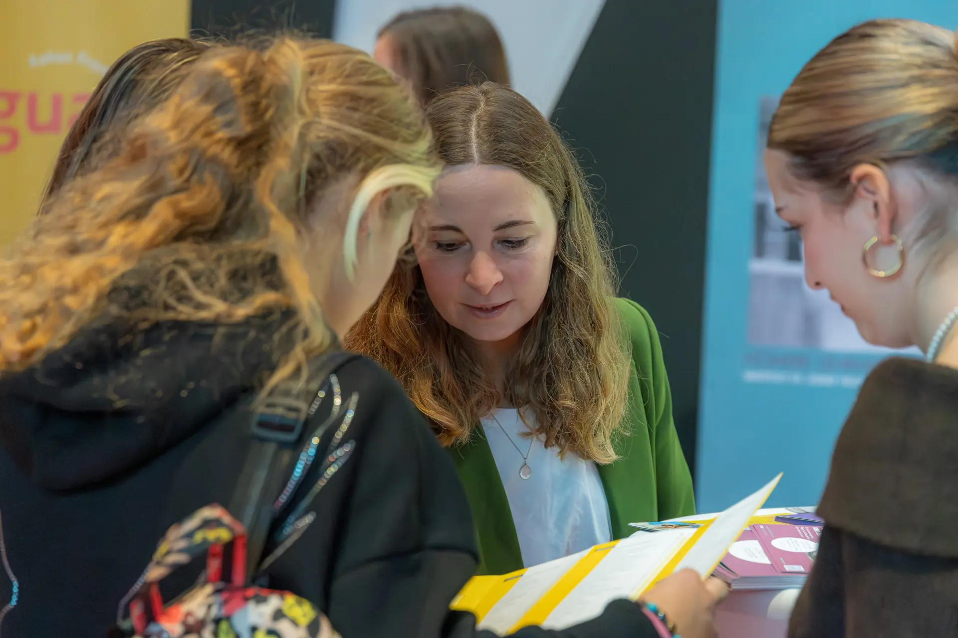 Drei Personen diskutieren über Dokumente.