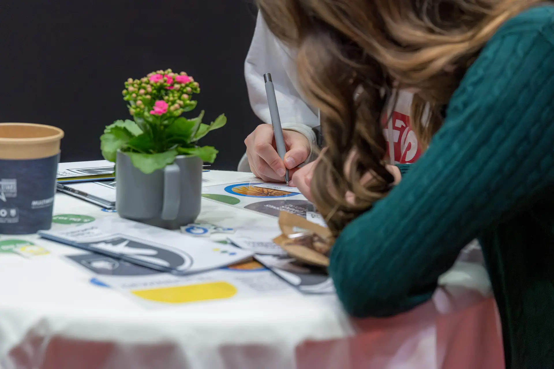 Zwei Personen schreiben an einem Tisch.