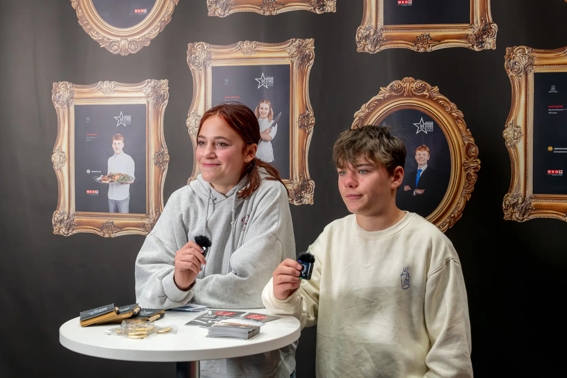 Zwei Personen an einem Tisch mit Mikrofonen.