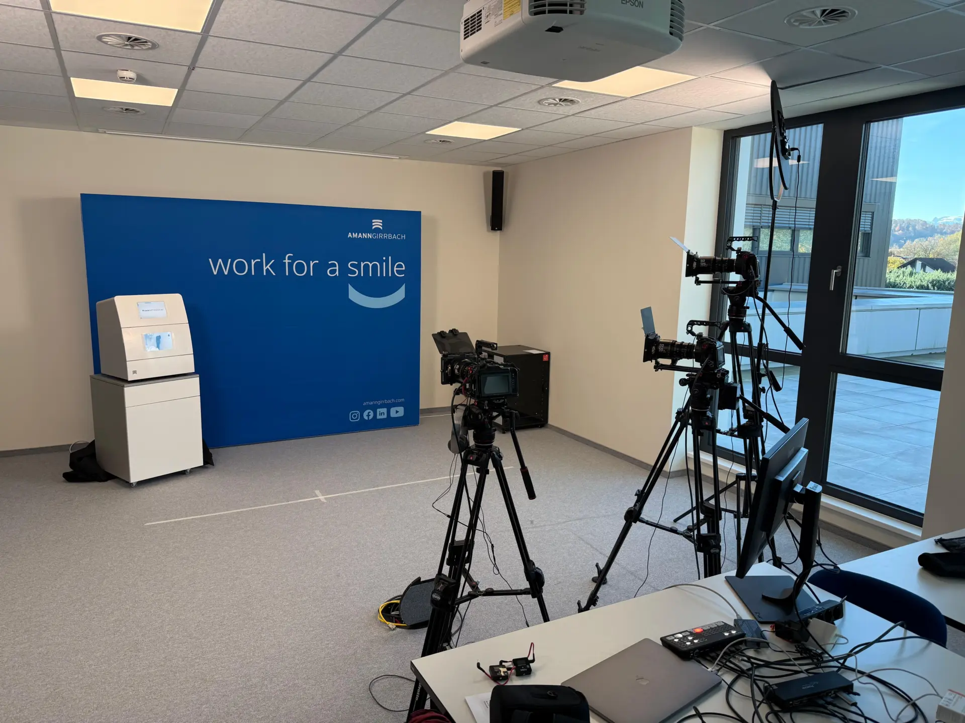 Kameraausrüstung in einem Büro mit blauem Werbeplakat.