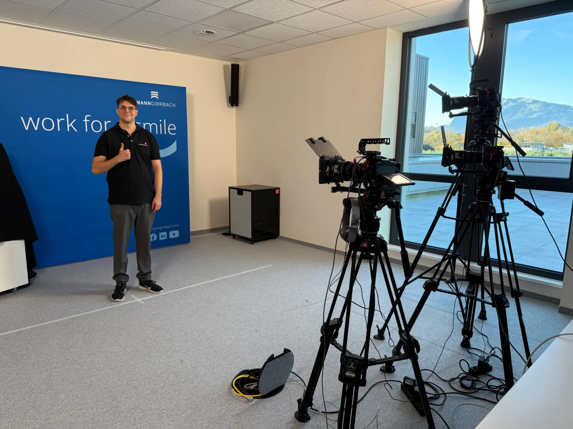 Mann posiert vor Kamera-Setup im Büro