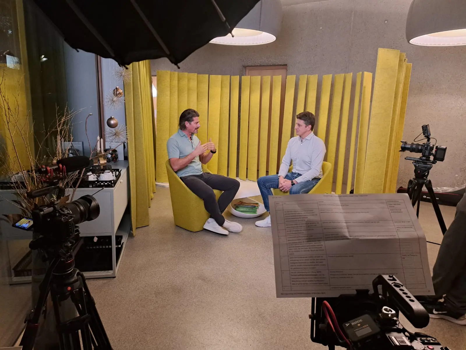 Zwei Männer sitzen in einem Interviewraum.