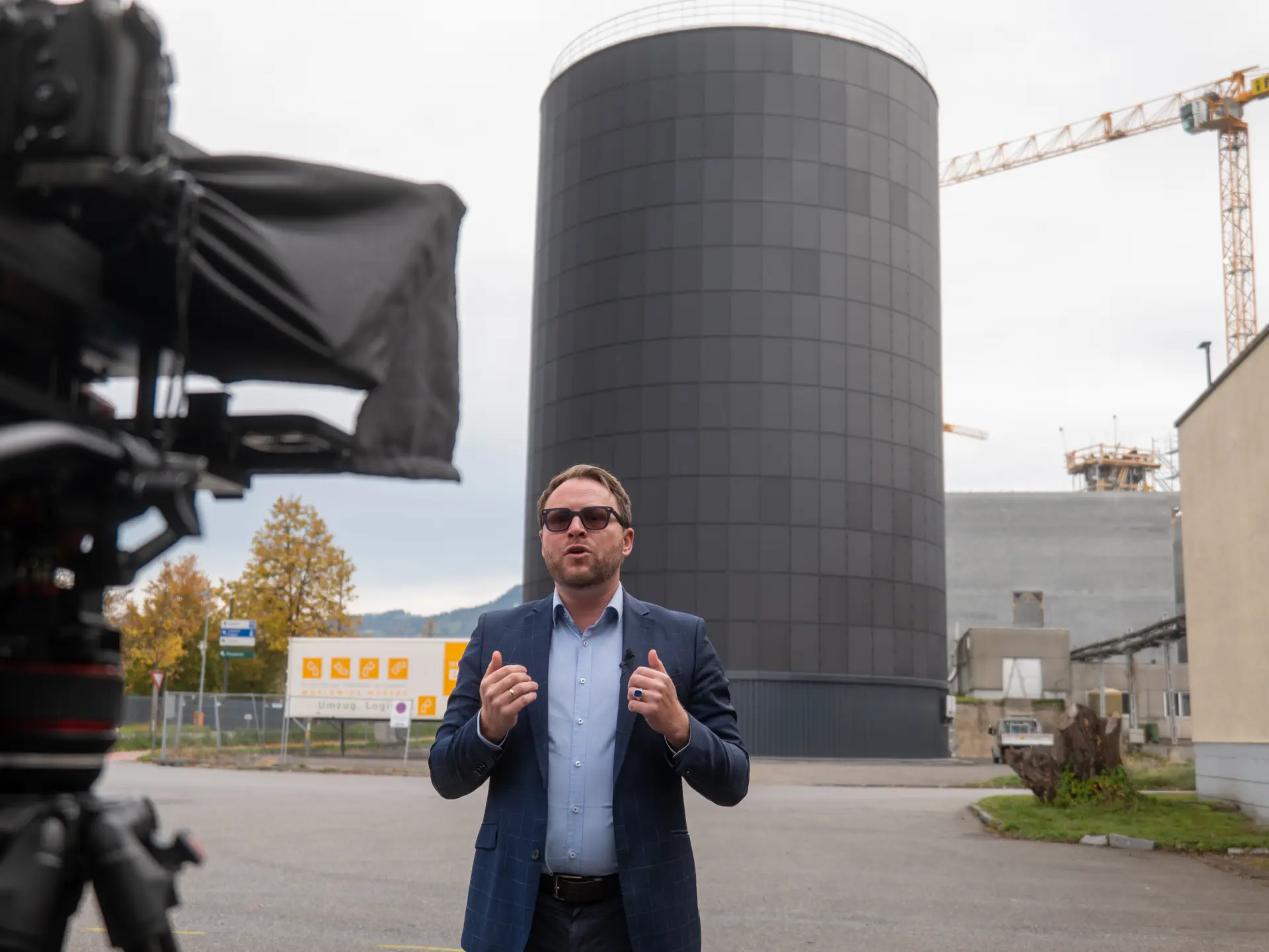 Mann spricht vor großem schwarzen Turm.