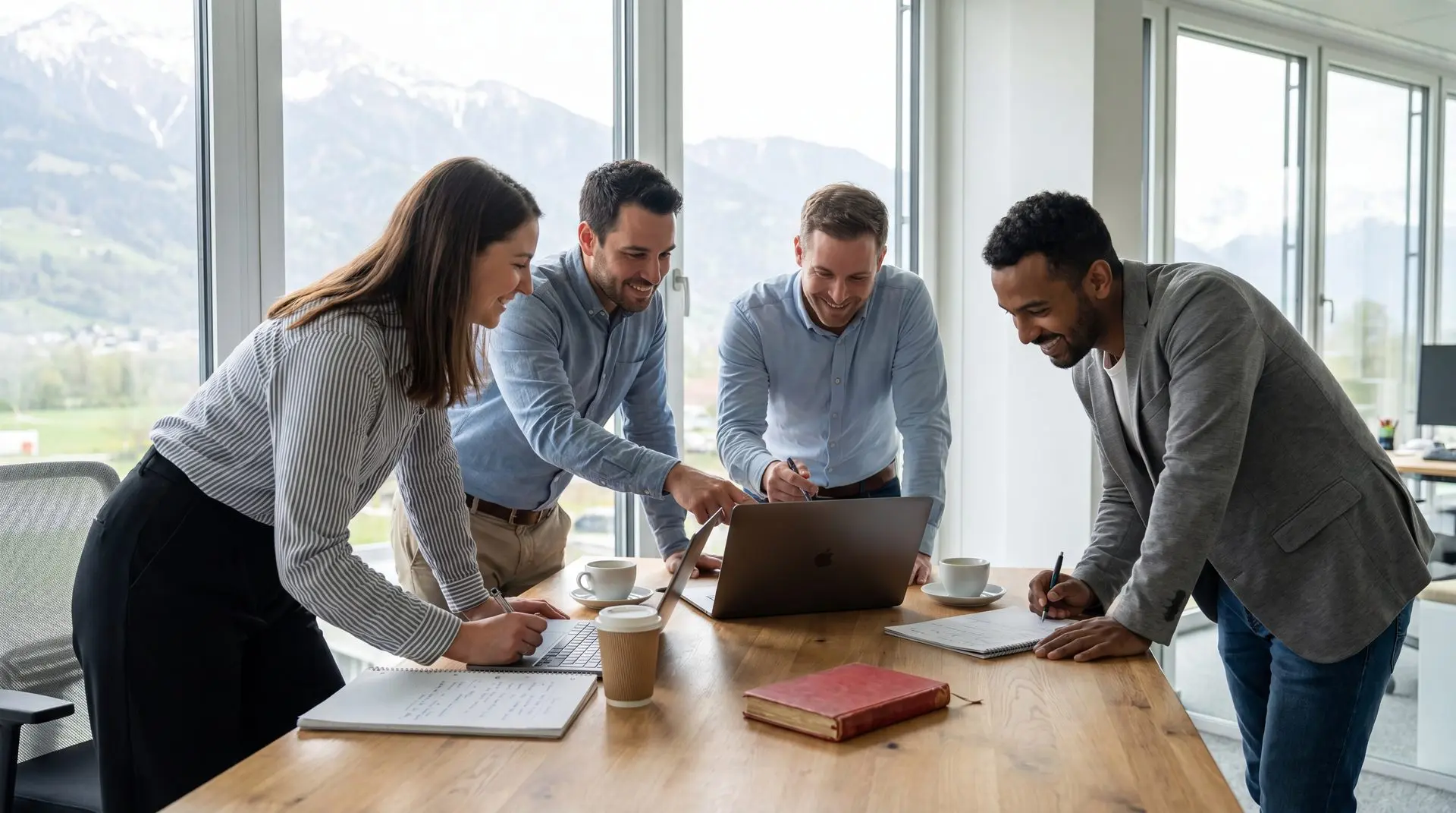 Vierköpfiges Team arbeitet gemeinsam an einem Tisch