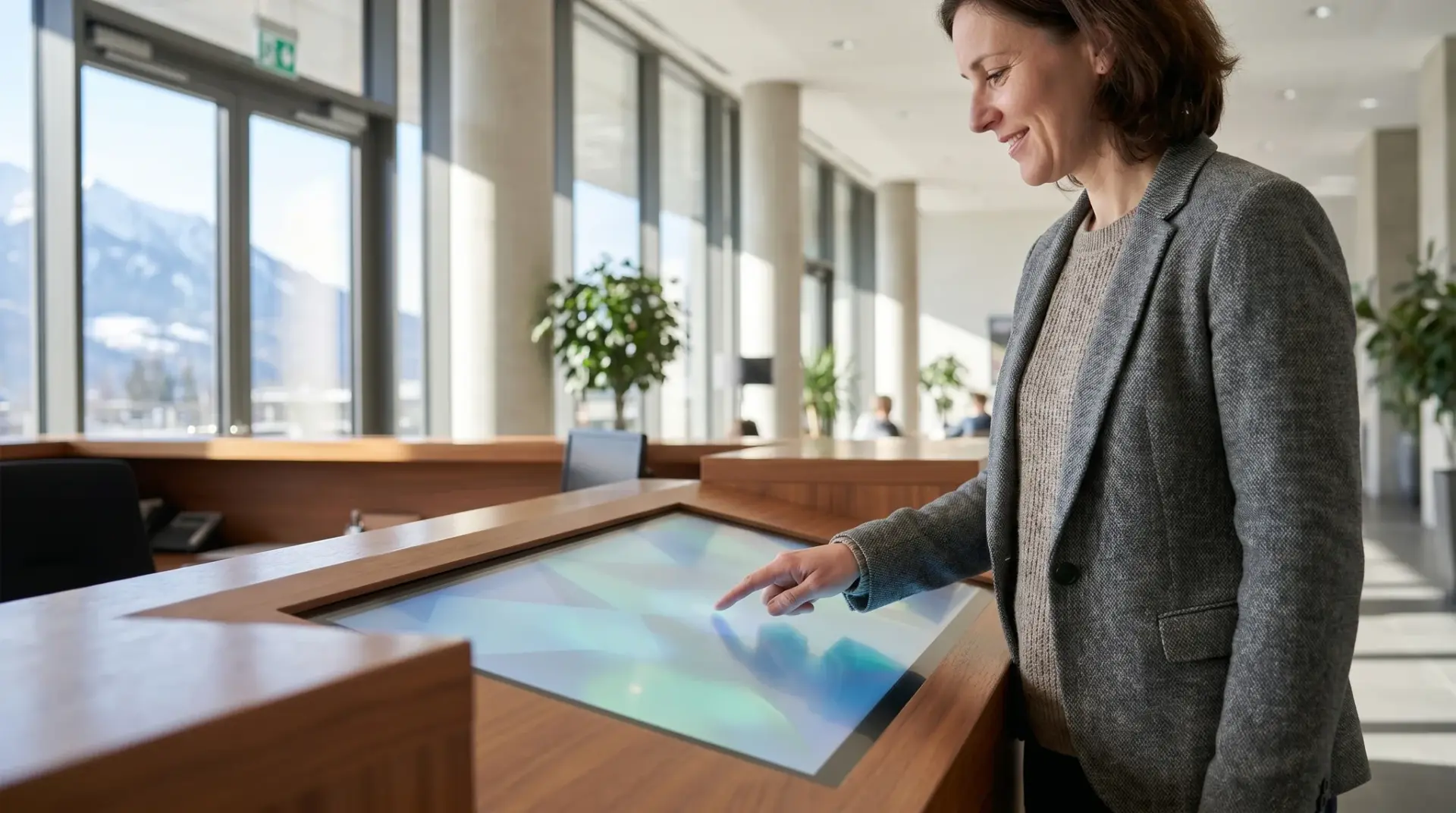 Besucherin tippt auf den digitalen Empfangs-Terminal und nutzt die Touch-Oberfläche