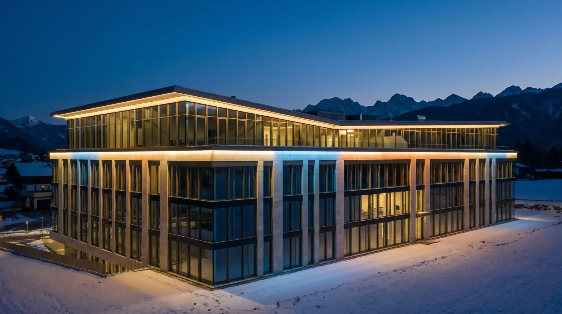 Beleuchtete Geschäftshaus-Fassade im Alpenraum mit gleichmäßiger Farbinszenierung am Abend