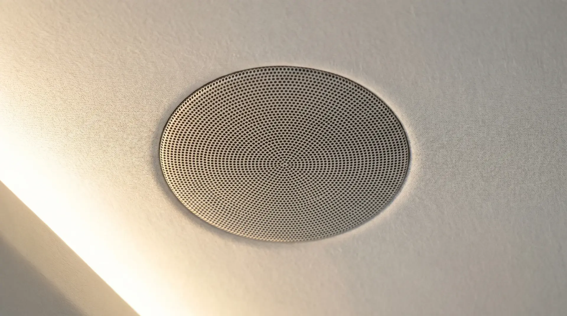 Nahaufnahme eines unsichtbar in eine Stoffdecke eingelassenen In-Ceiling-Lautsprechers