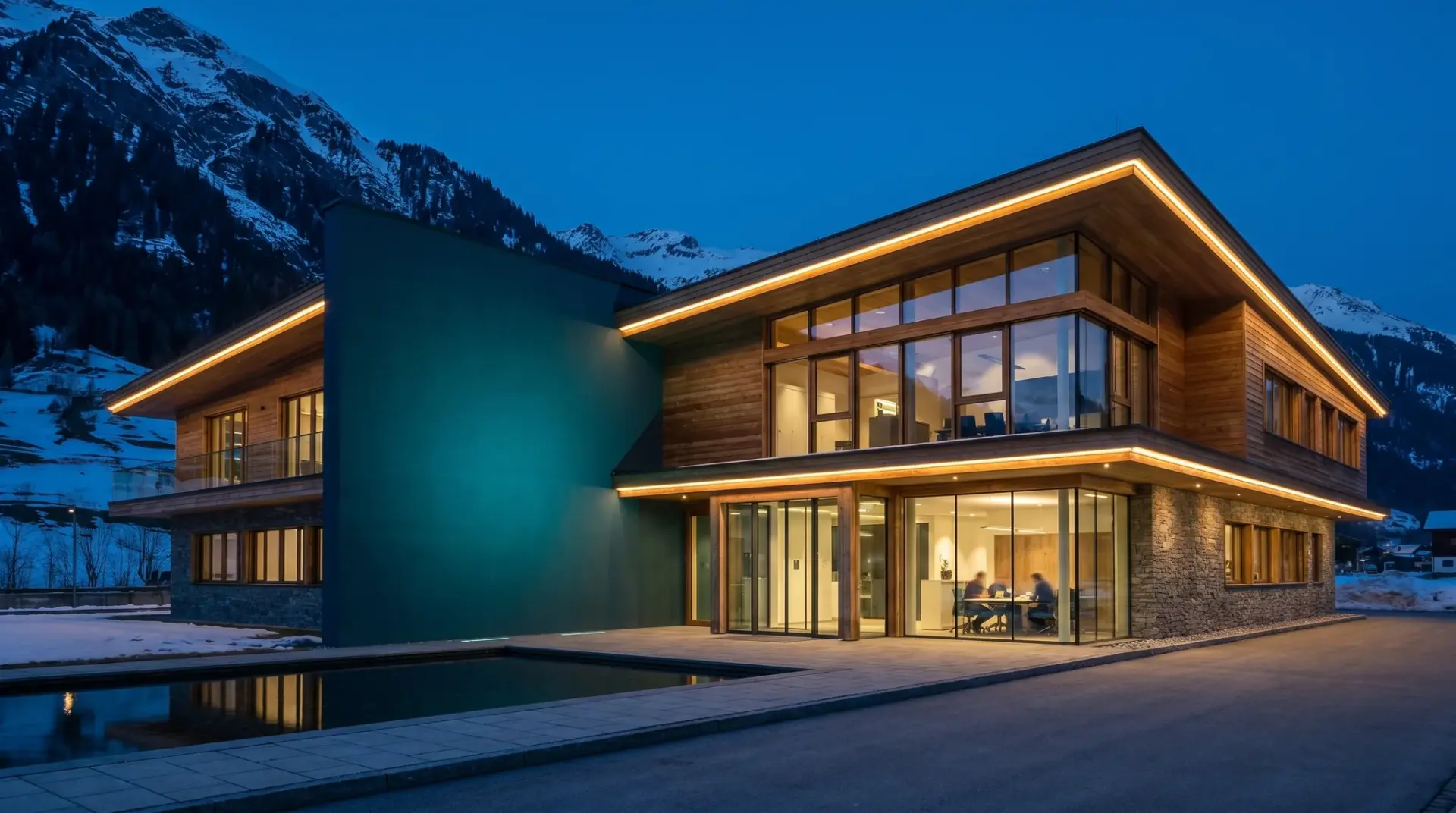 Industrie-Headquarter im Alpenraum mit beleuchteter Konturbeleuchtung und Wandflutung in Markenfarbe