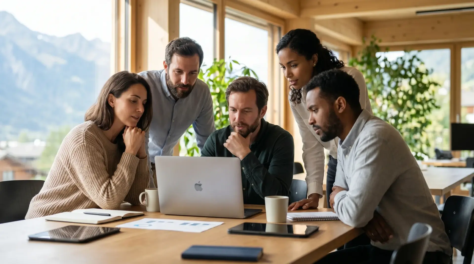 Internationales Team sieht eine mehrsprachige Schulung auf Laptop in modernem Büro
