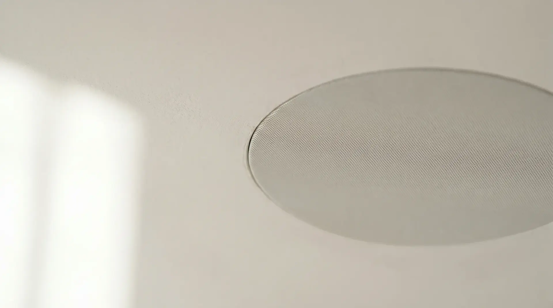 Detailaufnahme eines bündig in die Decke eingebauten Invisible-Lautsprechers
