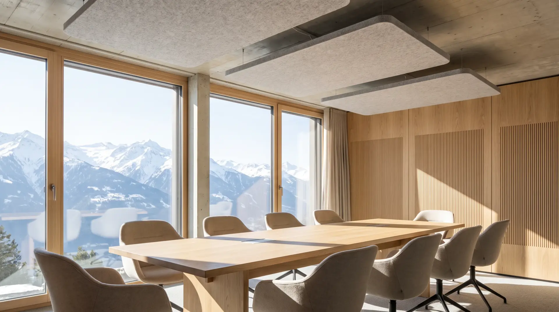 Heller Besprechungsraum mit Akustik-Deckensegeln und Holzlamellen-Wand mit Blick auf die Berge