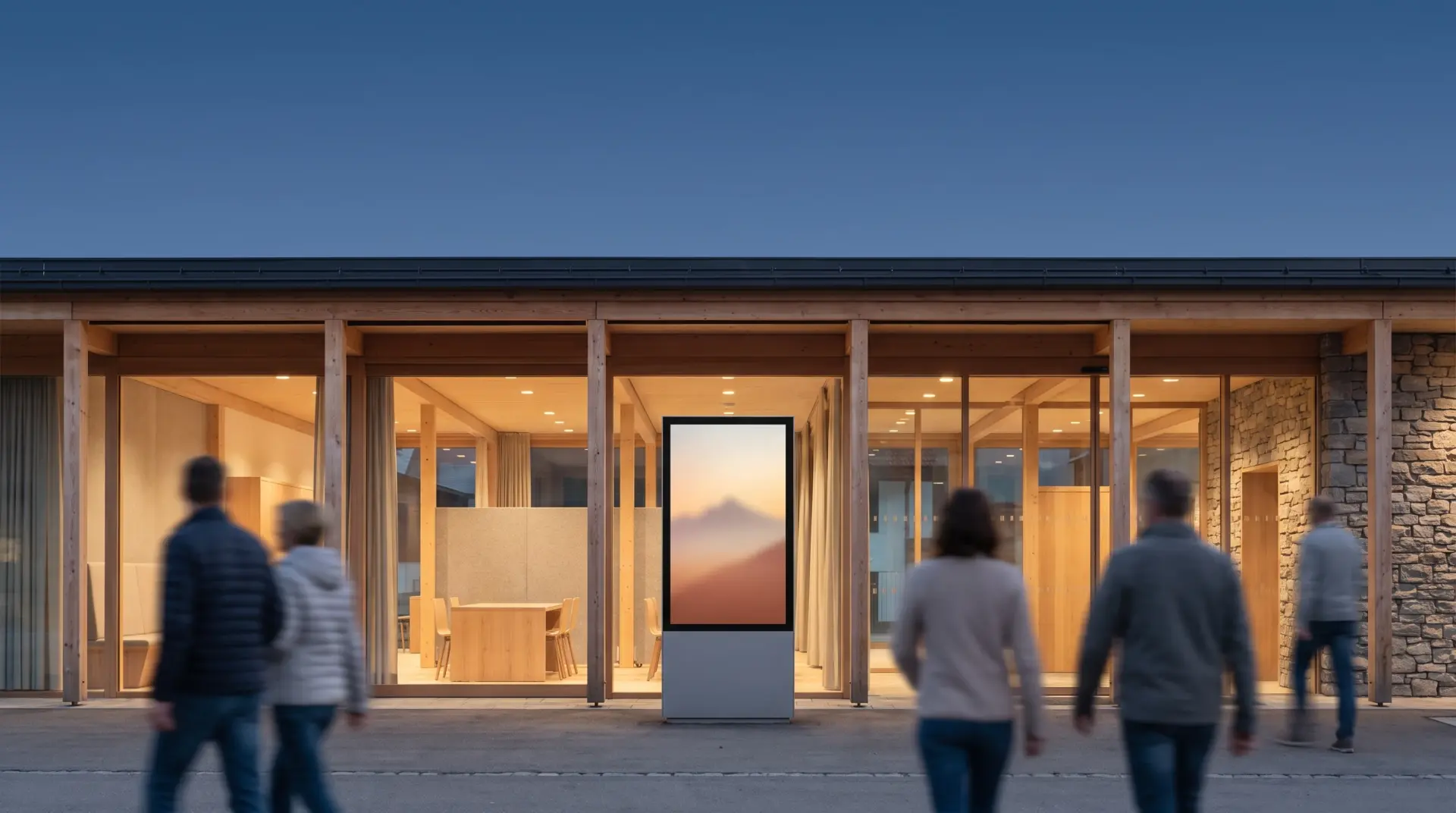 Gemeindeamt im Alpenraum im Abendlicht mit freistehender Outdoor-Stele davor