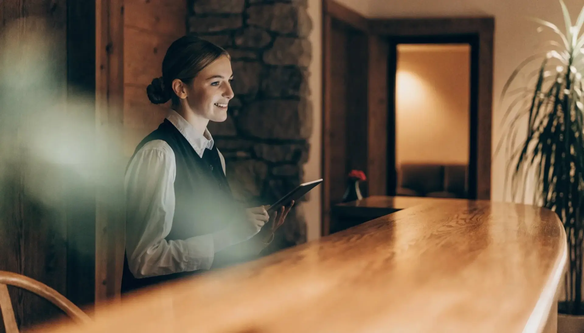 Funnel KI APP: Mitarbeiterin an der Hotelrezeption mit Tablet (MULTIMEDIAFABRIK, Koblach, Vorarlberg)