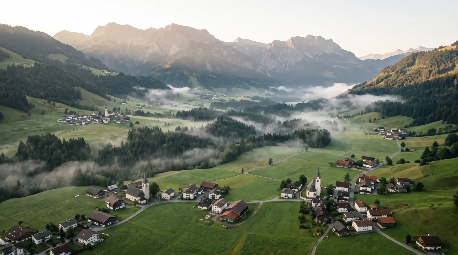 Luftaufnahme eines Alpentals in Vorarlberg mit mehreren kleinen Gemeinden im Morgennebel, Agendi KI APP, MULTIMEDIAFABRIK